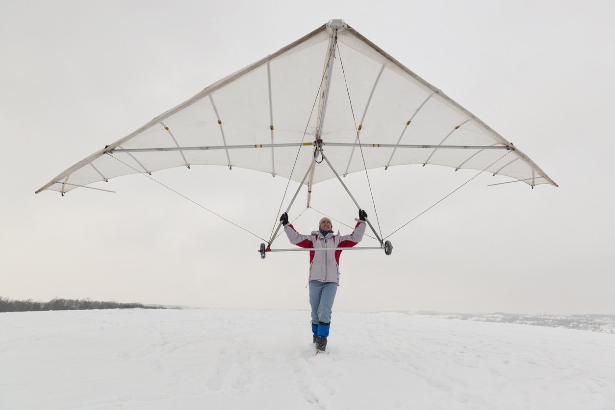 Girl holds an old hang glider wing.