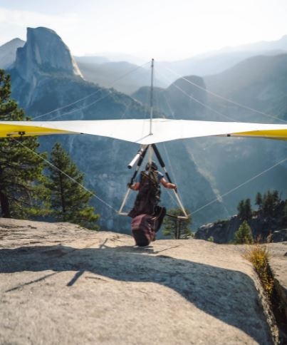 person on a mountain top about to hang glide