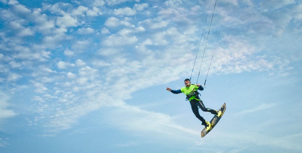 a man wearing a wetsuit riding a wakeboard