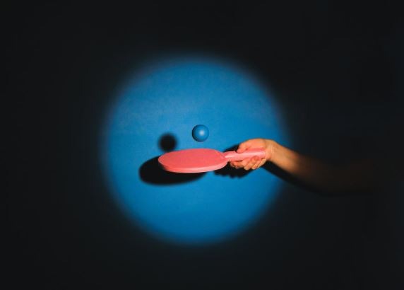 a person bouncing a ping pong paddle on a paddle