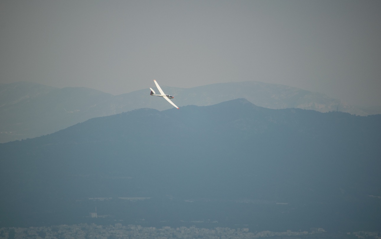 Sailplane flying over a mountain.