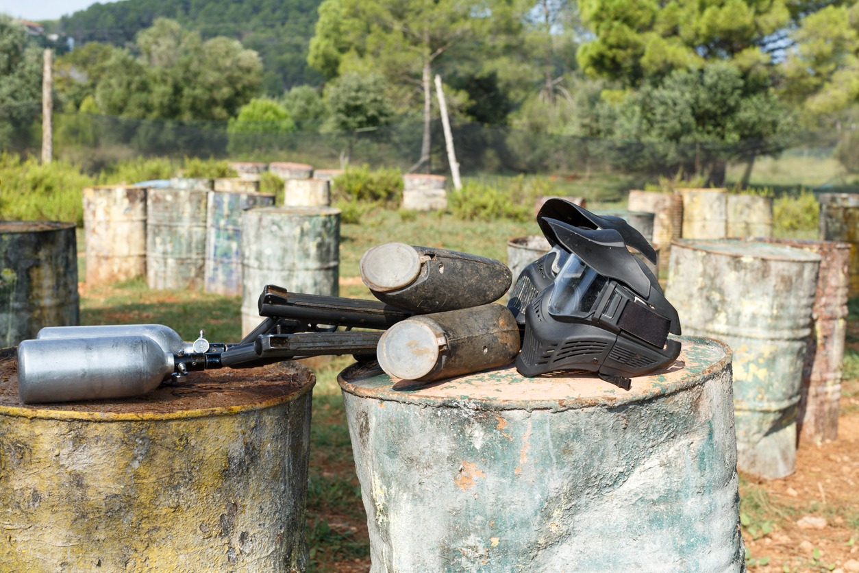 Protective masks and marker guns on paintball field