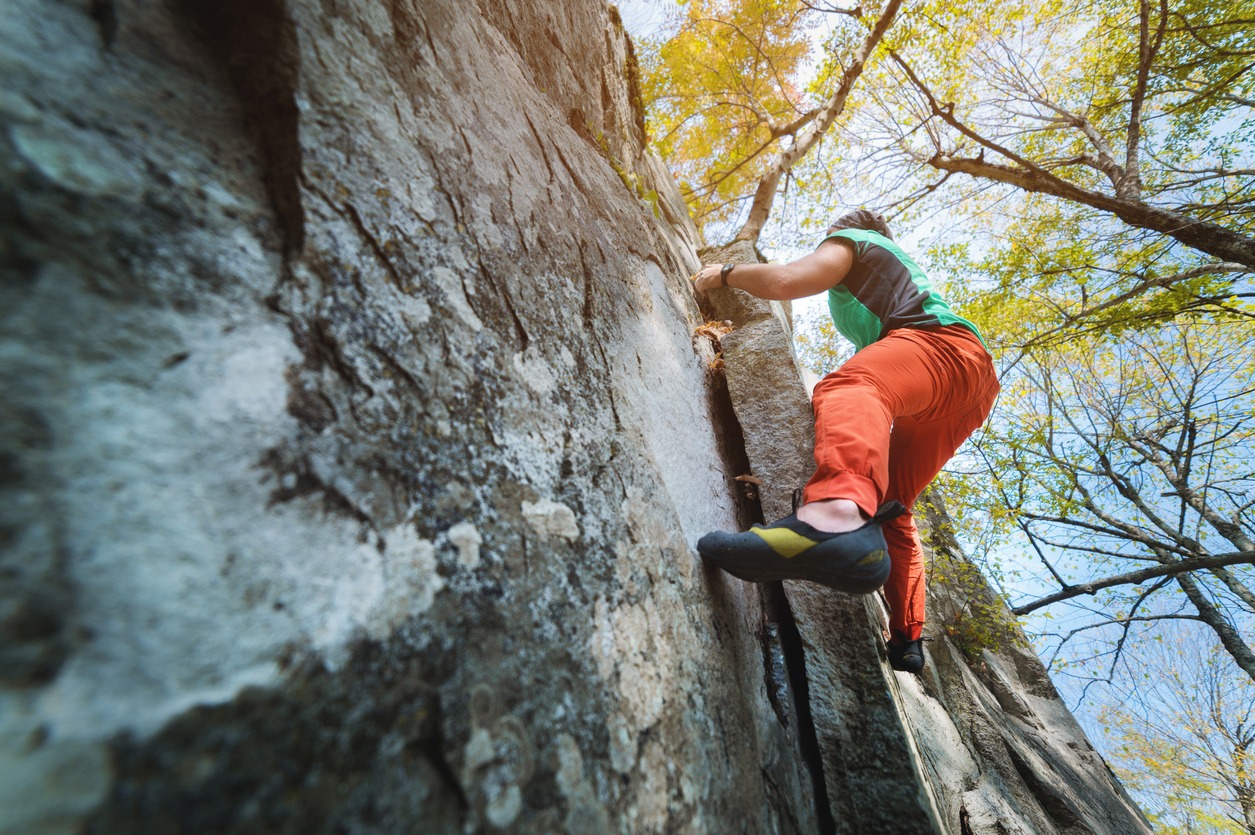 male climber hangs on a rock wall