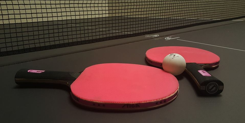 A pair of table tennis rackets on a ping pong table