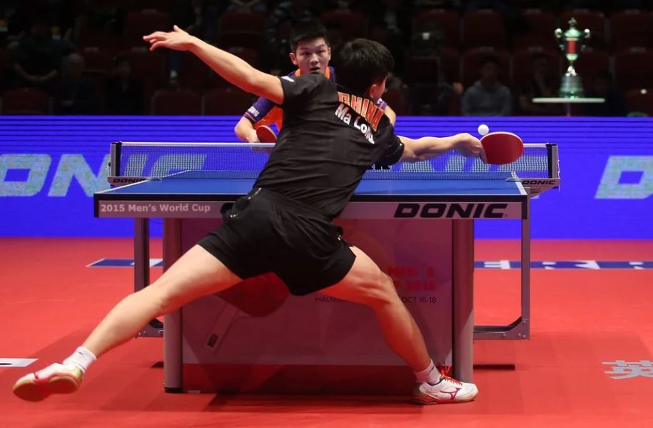 a Chinese player playing table tennis with his opponent