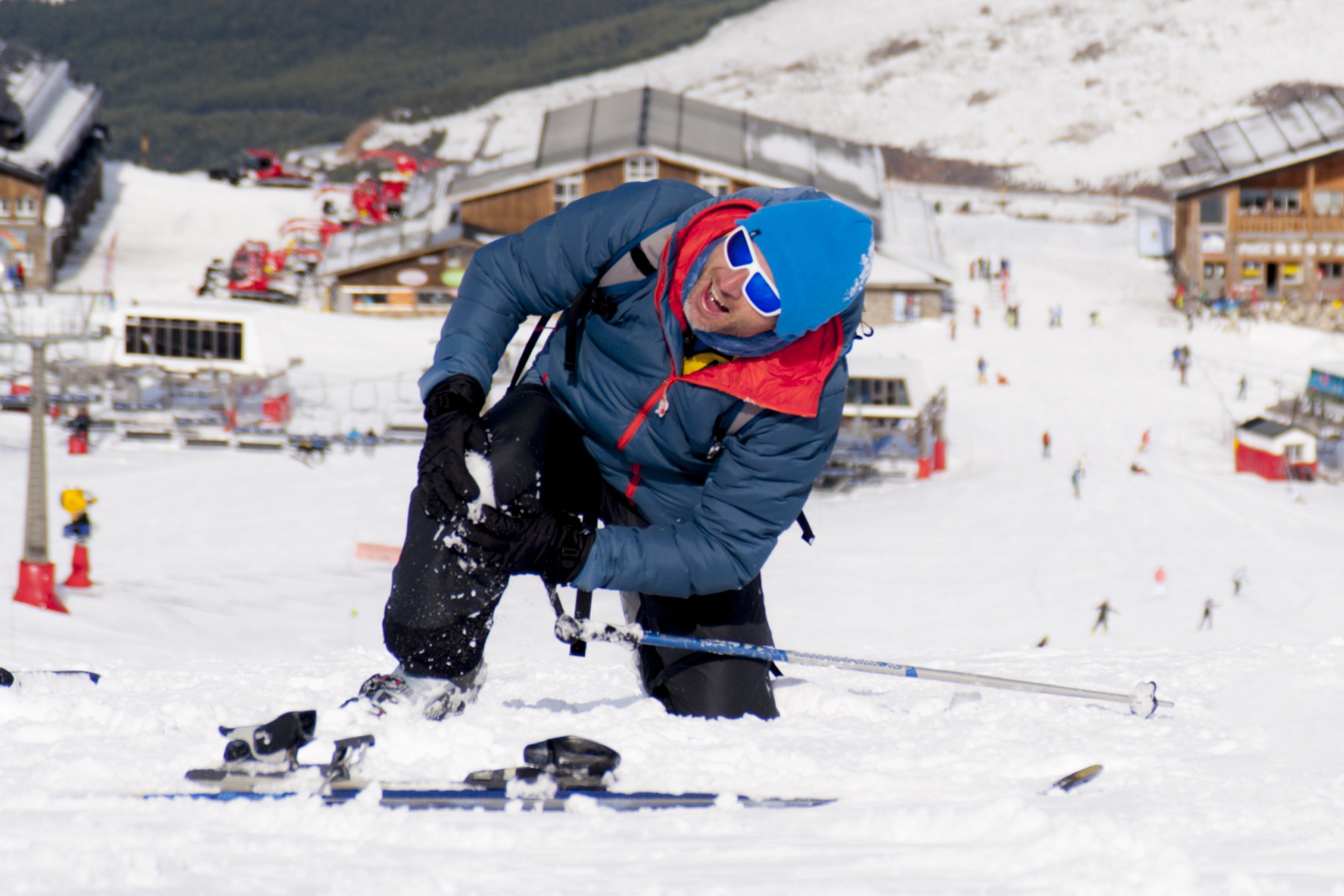 Man lying on snow ski crash injured knee in pain