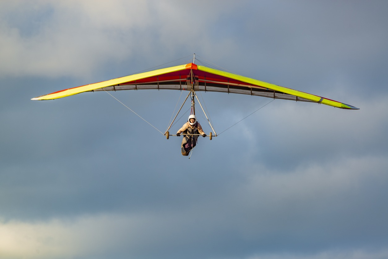 Beginner girl pilot withcolorful hang glider wing.