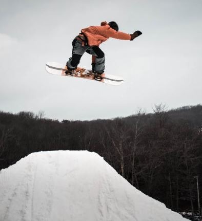 A man jumping on a ramp with his snowboard