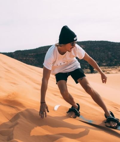 A man sandboarding in the desert