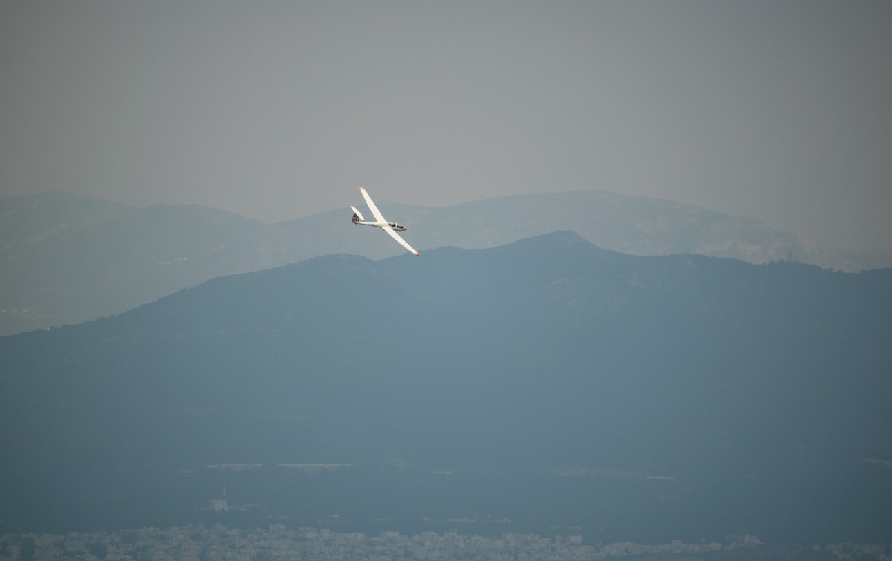 Sailplane flying over a mountain.