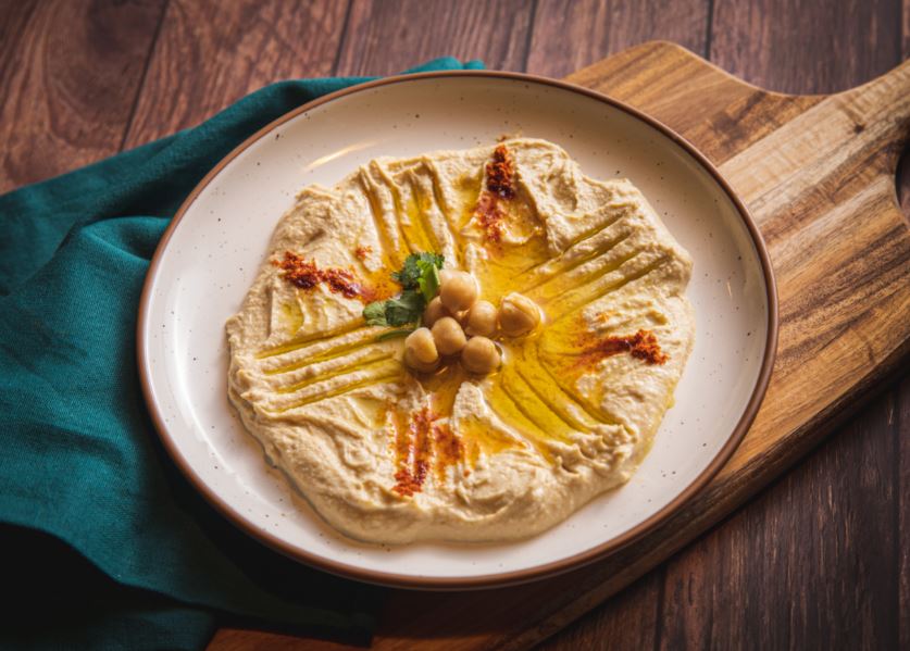 Hummus in a bowl with olive oil on top.